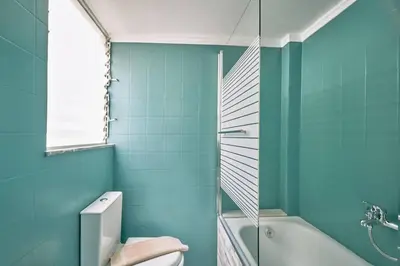 a bathroom with blue walls and a toilet and a shower at evgenia's city apartment in Chania Town