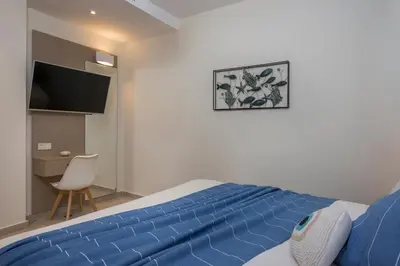 a bedroom with a bed with a blue blanket at Kolymbari Sea Front Cozy Apartments in Kolymvari