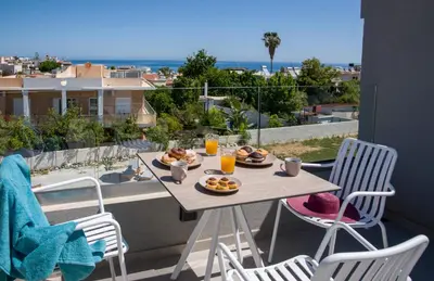 a table with plates of food on a balcony at Eleanthi Modern Living in Galatás
