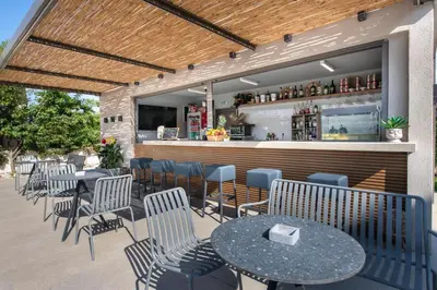 a restaurant with tables and chairs and a bar at Eleanthi Modern Living in Galatás