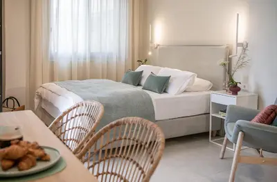 a bedroom with a bed and a table and chairs at Margiani Studio & Apartment in Chania Town