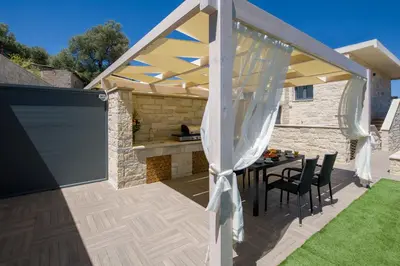 a pergola on a patio with a table and chairs at TWIN'S HOME LUXURY SUITES in Alikianós