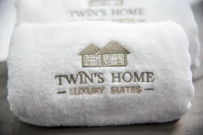 a towel with the words twins home luxury suites on it at TWIN'S HOME LUXURY SUITES in Alikianós