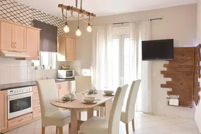a kitchen with a wooden table with chairs and a dining room at Casa de Campo 2 in Almirida