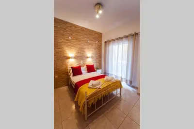 a bedroom with a bed and a brick wall at jenny's flat near the sea in Galatás