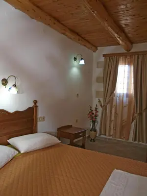 a bedroom with two beds and a window at Vafes Traditional Stone Houses in Vafés