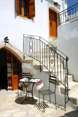 a patio with a table and chairs next to a staircase at Vafes Traditional Stone Houses in Vafés