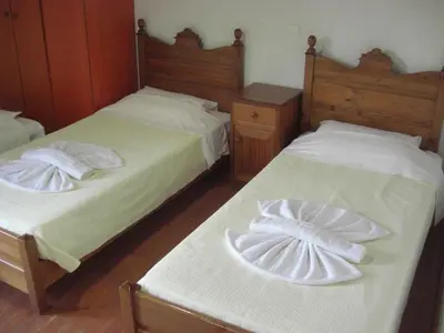 two beds in a bedroom with white sheets at Patriko Traditional Stone Houses in Vafés