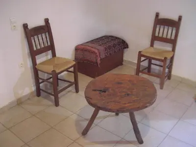 a room with three chairs and a table and a bed at Patriko Traditional Stone Houses in Vafés