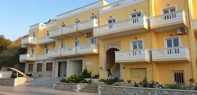 a large yellow building with white balconies at Kalyves Bay in Kalyves