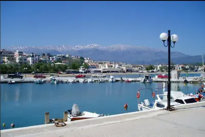 a marina with boats in the water and a city at Kalyves Bay in Kalyves