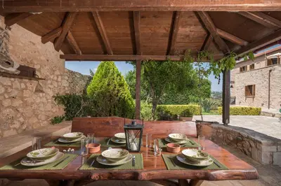 a wooden table with plates and dishes on it on a patio at Xatheri Villas in Vamos