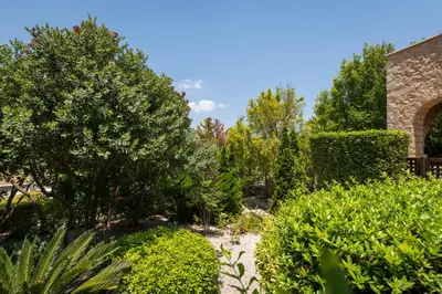 a garden with bushes and trees and a brick building at Xatheri Villas in Vamos