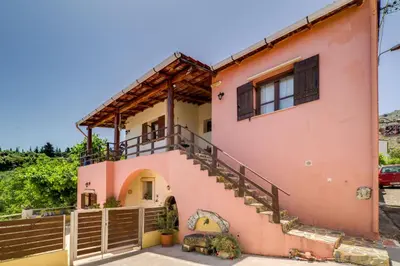 a pink house with stairs and a fence at Villa Zoi Tzitzifes in Tzitzifés
