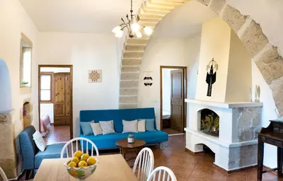 a living room with a blue couch and a fireplace at Villa Zoi Tzitzifes in Tzitzifés