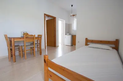 a bedroom with a bed and a dining room with a table at Elena Rooms & Apartments in Gerani Chanion