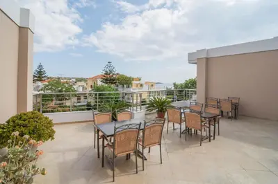 a patio with tables and chairs on a balcony at Relax Hotel in Palaiochóra
