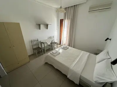 a bedroom with a bed and a table and chairs at Filoxenia Studios 1 in Palaiochóra