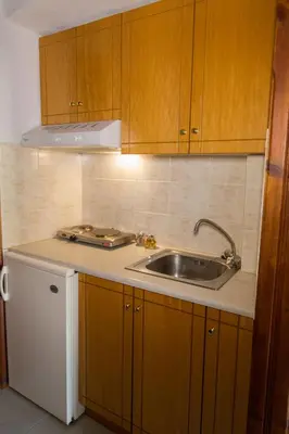 a kitchen with wooden cabinets and a sink at Filoxenia Studios 1 in Palaiochóra