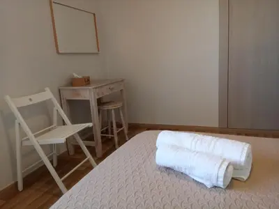 a bedroom with a bed and a chair and a table at Villa Anastasia in Kalamaki Chanion