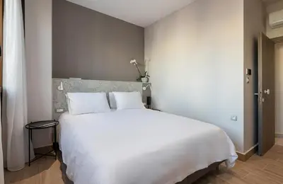 a bedroom with a large white bed with white pillows at Al Daliani Minaret Rooms in Chania Town