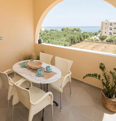 a dining room with a table and chairs and a window at Eden of grameno Luxury sea view apartment in Palaiochóra
