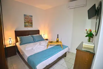a bedroom with a bed with a night stand and a television at *Haritos traditional Apt-5min from Falassarna Bch* in Kissamos