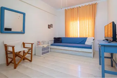 a living room with a blue couch and a mirror at Sunset Home with sea view in Chania Town