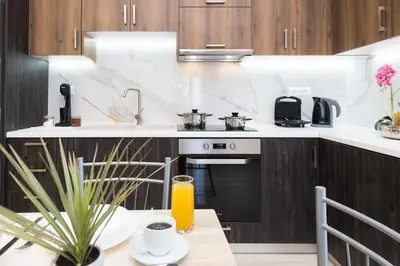 a kitchen with a sink and a stove and a table at Gardenia Apartment in Kissamos