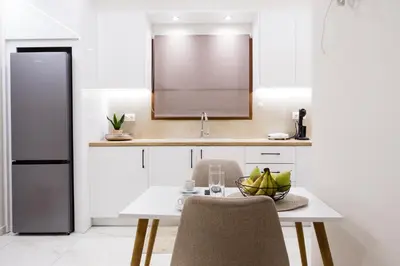 a kitchen with a table with two chairs and a sink at Gardenia Apartment in Kissamos