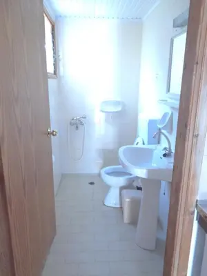a white bathroom with a sink and a toilet at LITHI in Palaiochóra