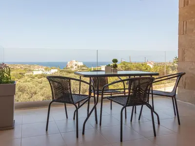 a table and chairs on a balcony with a view of the ocean at Cretan fleur apartments in Elafonisi