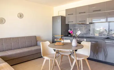 a kitchen with a table and chairs and a couch at Cretan fleur apartments in Elafonisi