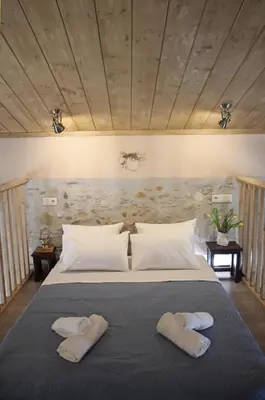 a bedroom with a large bed with two towels on it at Laini Guest Houses in Koulkouthianá