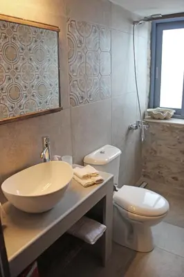 a bathroom with a sink and a toilet at Laini Guest Houses in Koulkouthianá