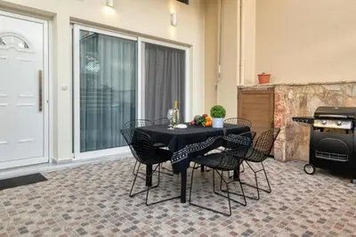 a dining room with a table and chairs and a grill at Villa Hope in Chania in Mourniaí