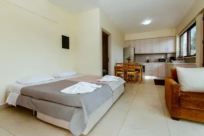 a bedroom with a large bed and a kitchen at Chania Oasis with heated pool in Chania Town