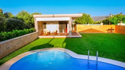 a backyard with a swimming pool in the grass at Chania Oasis with heated pool in Chania Town