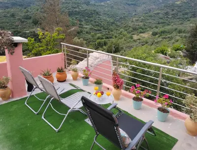 a balcony with a table and chairs and plants at Rocky Mountain Villa in Ramní