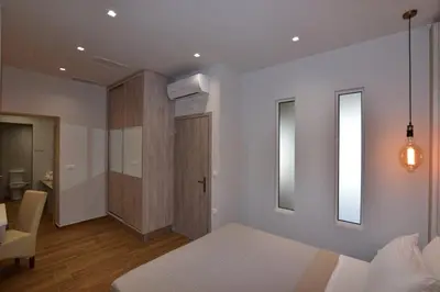 a bedroom with a bed and a chair and a mirror at Gonis Grand Luxury Suite in Palaiochóra