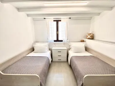 two beds in a small room with a window at PRIMAVERA in Kalamaki Chanion