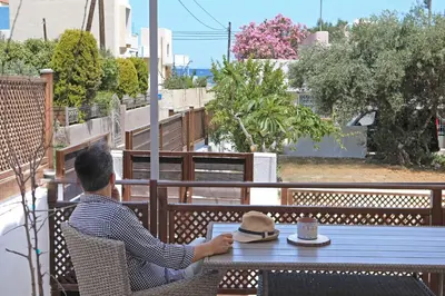 a man sitting at a table with a laptop at PRIMAVERA in Kalamaki Chanion