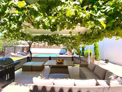 a patio with a couch and a table under a tree at PRIMAVERA in Kalamaki Chanion