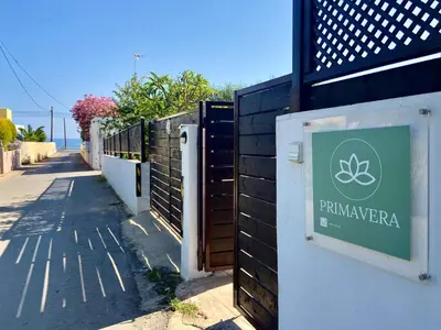 a fence with a sign on it next to a sidewalk at PRIMAVERA in Kalamaki Chanion