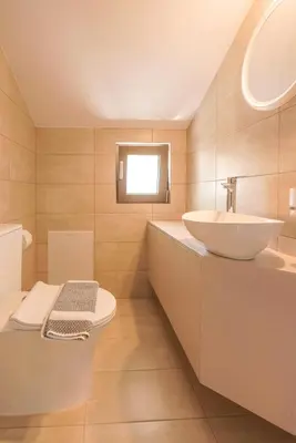 a white bathroom with a sink and a toilet at Pink Sand Villas in Agios Padeleimon