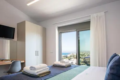 a bedroom with a bed and a large window at Centro Golden View Villa in Chania Town