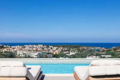 a pool with two chairs and a view of a city at Centro Golden View Villa in Chania Town