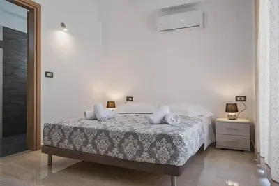 a bedroom with a bed with white sheets and pillows at Park-view Lux Pool Villa, steps to the Beach in Aghii Apostoli