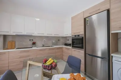 a kitchen with a bowl of fruit on a glass table at Park-view Lux Pool Villa, steps to the Beach in Aghii Apostoli