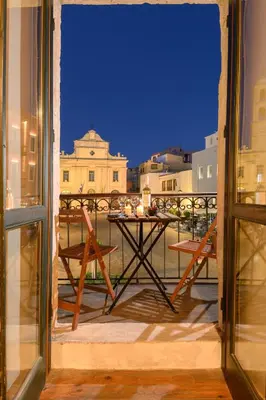 a table on a balcony with a view of the city at Monastery apartment, a unique house in Chania Town